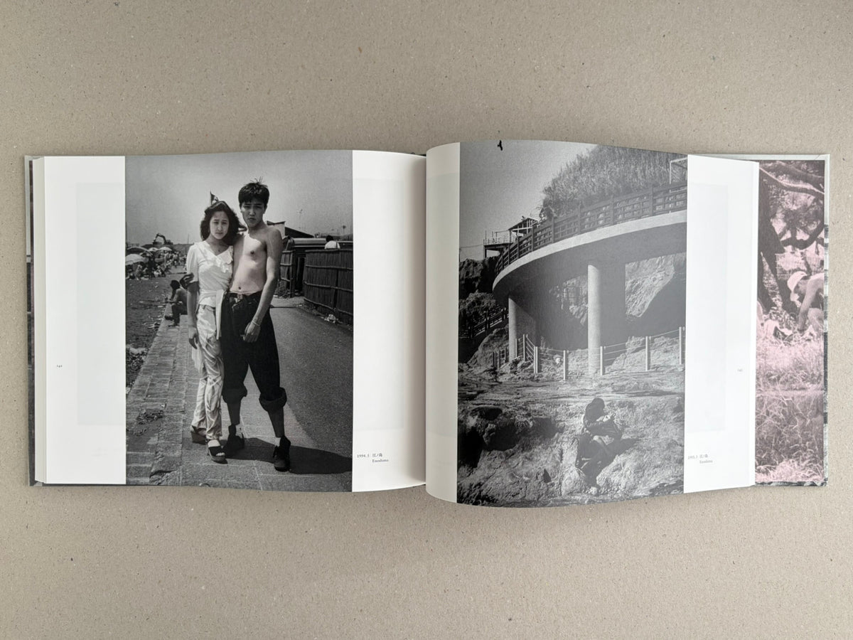 Open spread from Obi and Sand: Kyoto/Enoshima showing black-and-white photographs, including a couple standing on a seaside path and a curved structure on a rocky shore.