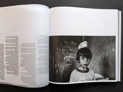Oleksandr Glyadyelov photograph of a Ukrainian boy indoors with a small white chick sitting on his head, printed next to essay text.
