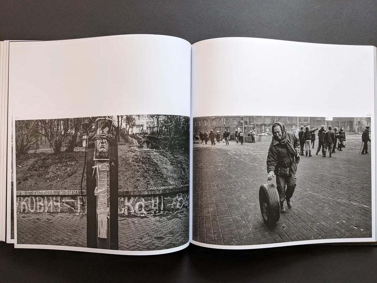 Oleksandr Glyadyelov images of a protest effigy tied to a post and a man rolling a tyre across a city square after demonstrations.
