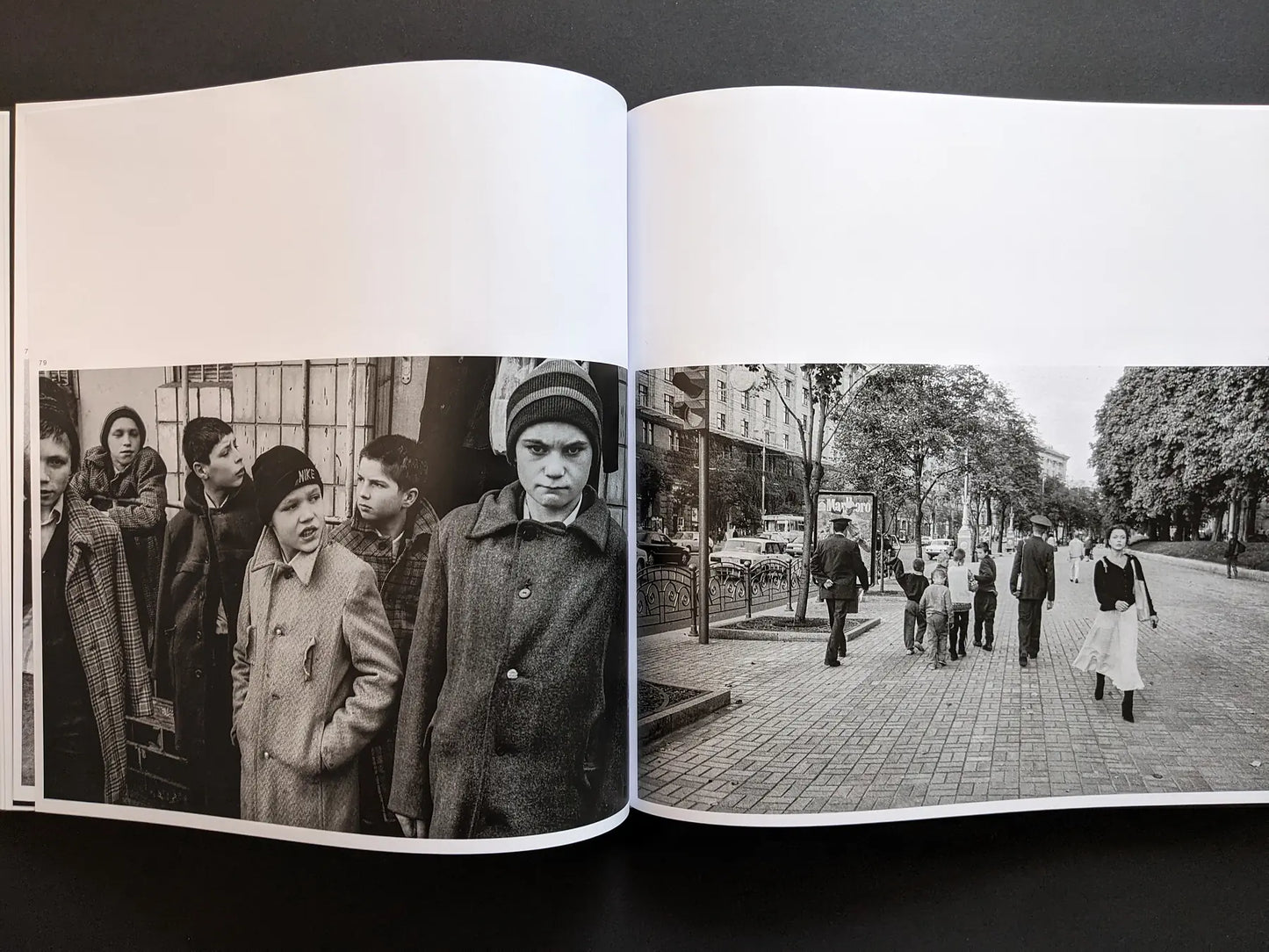 Black and white spread by Oleksandr Glyadyelov showing street children in coats and a busy Kyiv boulevard with families walking.