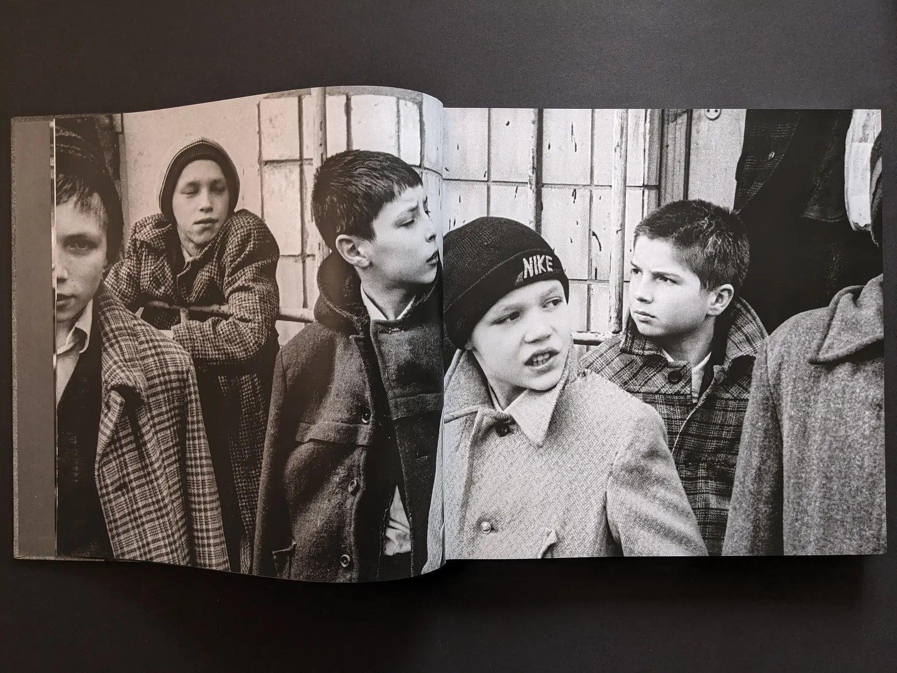 Inside spread from Oleksandr Glyadyelov with a group of boys standing together outside on a city street.
