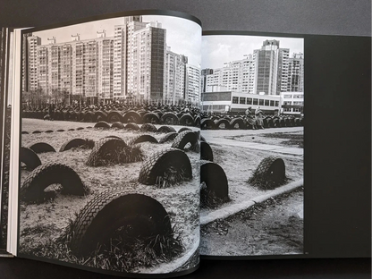 Inside spread from Oleksandr Glyadyelov with rows of half-buried tyres in a playground in front of large apartment blocks.