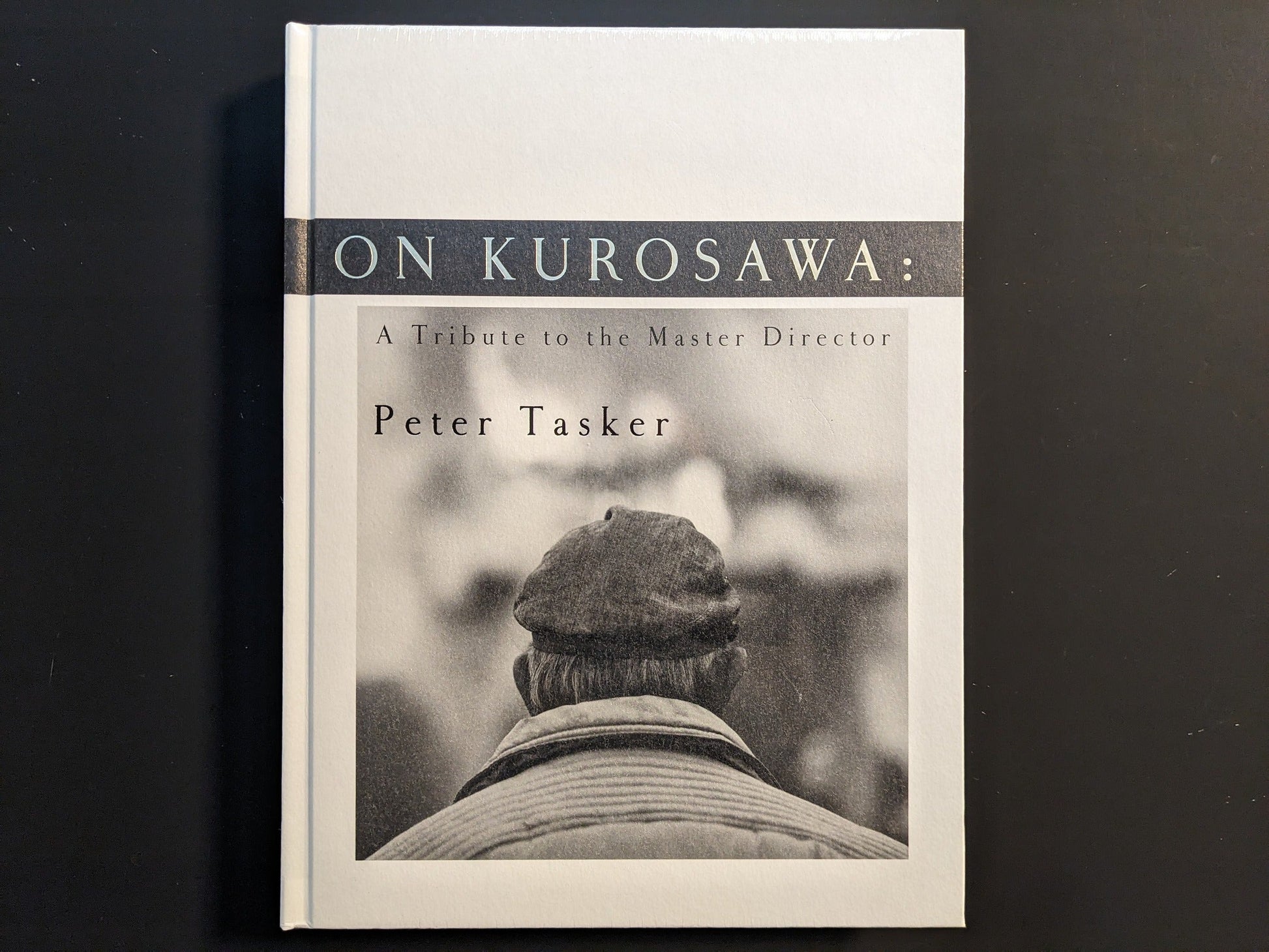 Front cover of “On Kurosawa: A Tribute to the Master Director” by Peter Tasker, hardcover with monochrome portrait design.