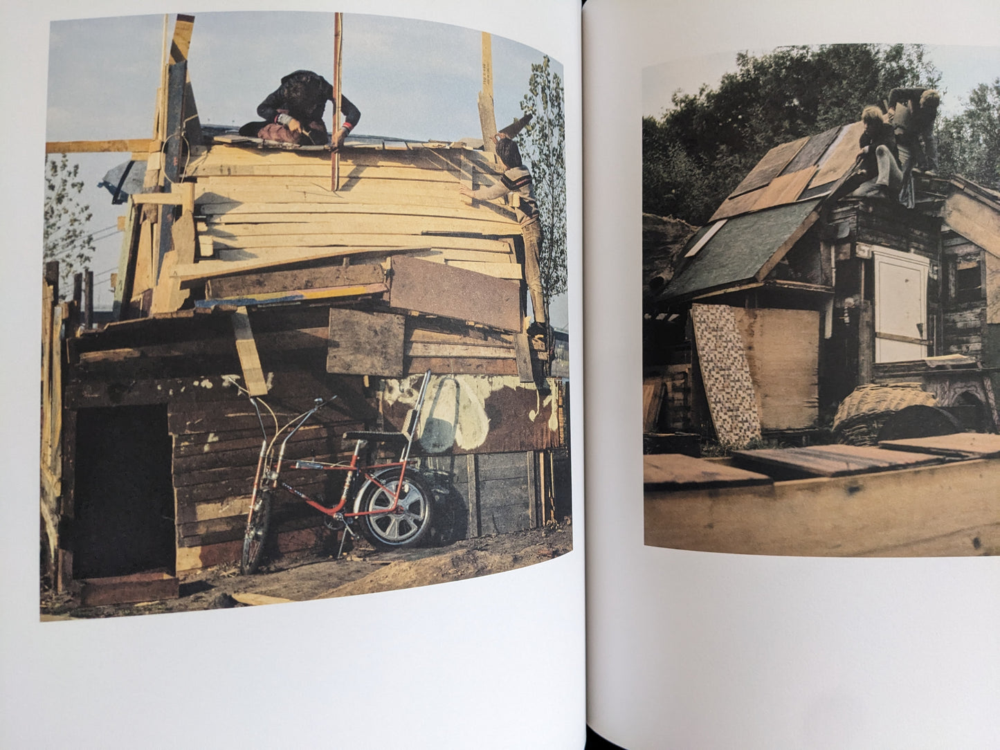 Open spread with black-and-white photographs of children constructing wooden huts and working beside a goat.