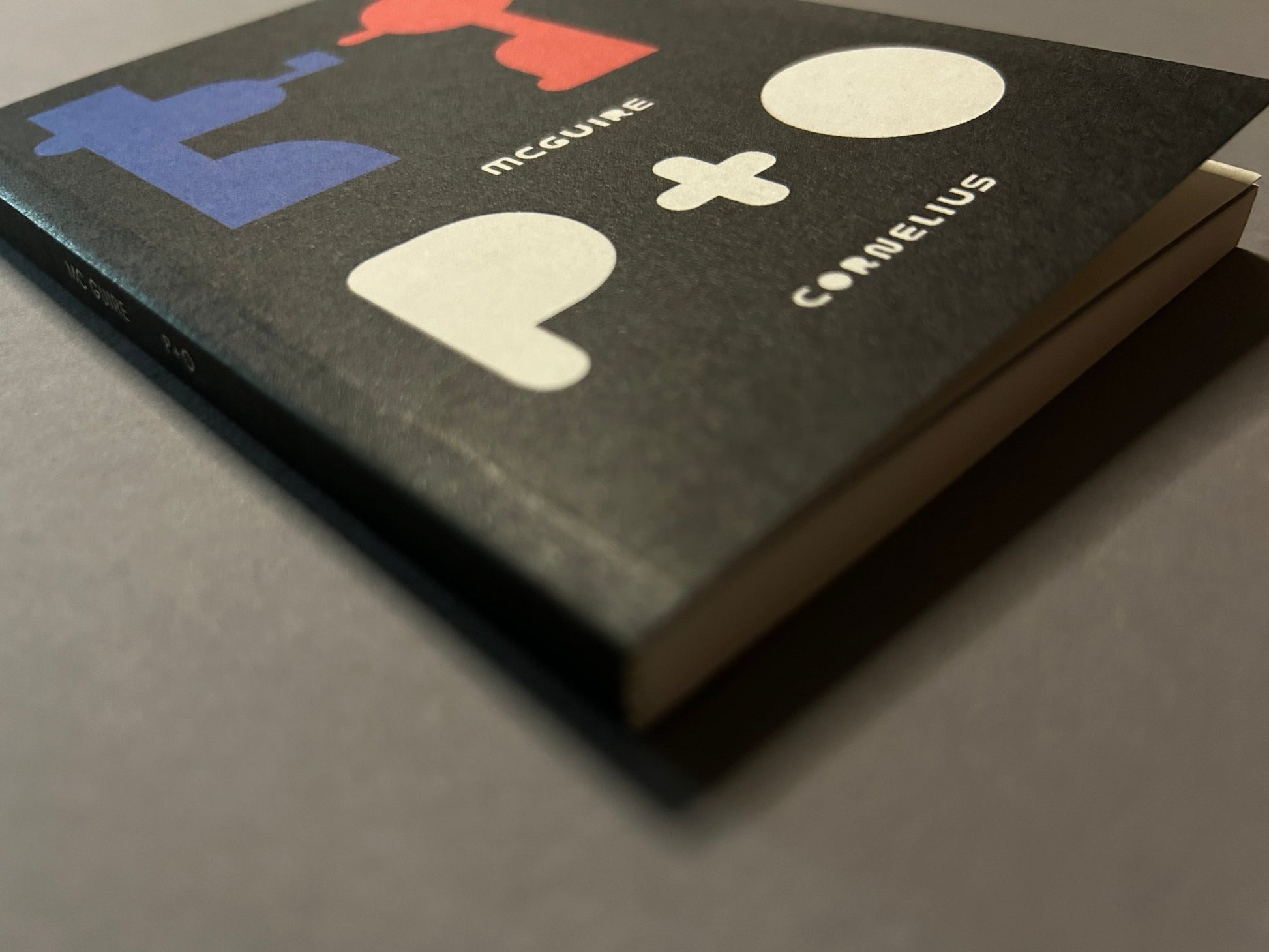 P+O by Richard McGuire, angled cover view showing the black paperback and its thick spine