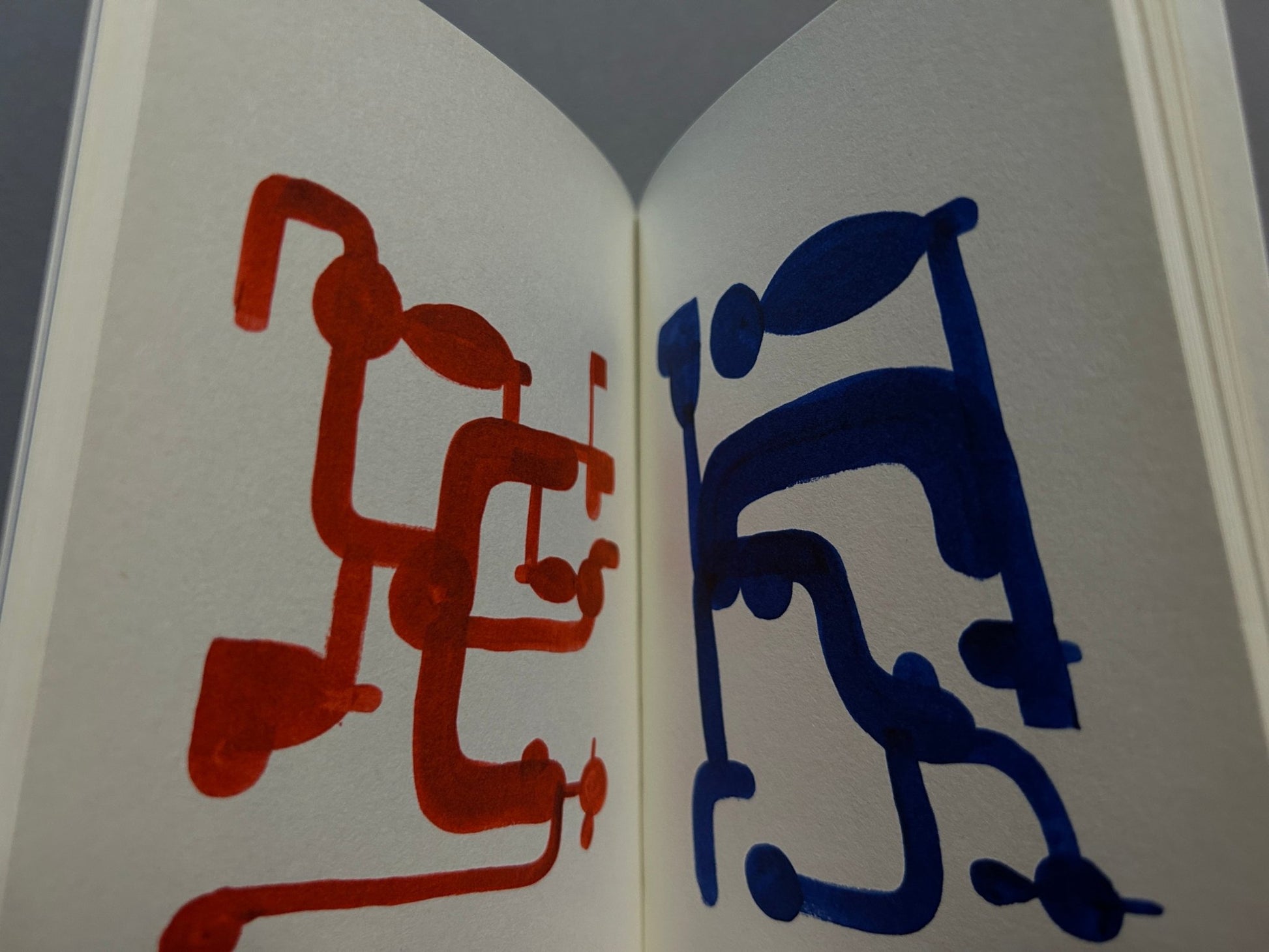 Interior spread from P+O by Richard McGuire showing red and blue abstract cartoon figures on facing pages