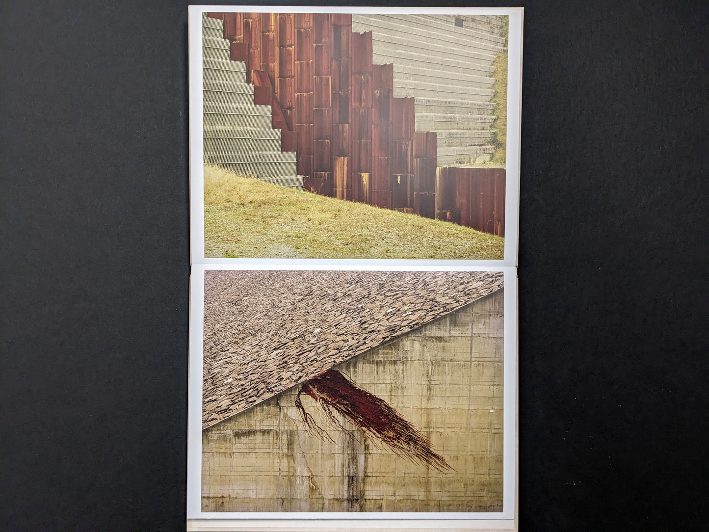 Open leporello spread showing a rusted steel retaining wall, concrete steps, and a sloped embankment.