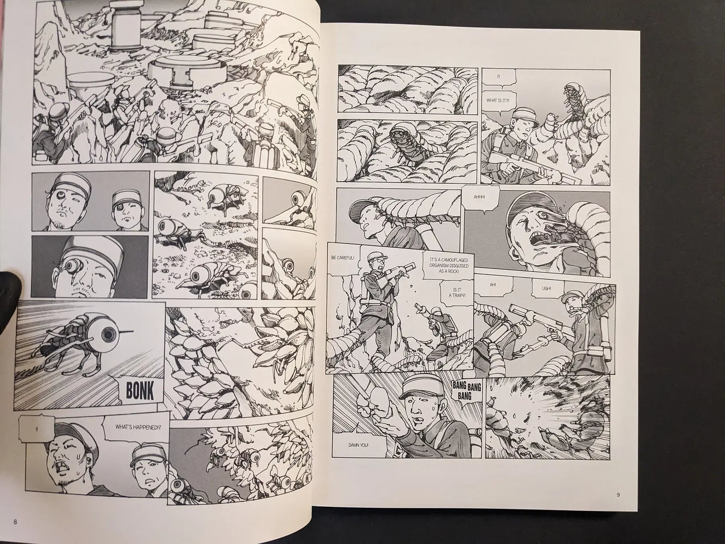 Interior spread from “Parasitic City #3” showing soldiers in a rocky landscape attacked by worm-like parasites in black-and-white manga panels.