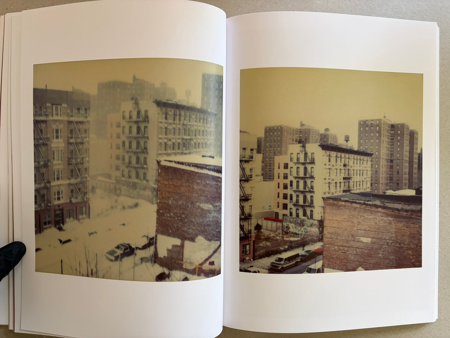 Open spread with two cityscape photographs of snowy apartment buildings.