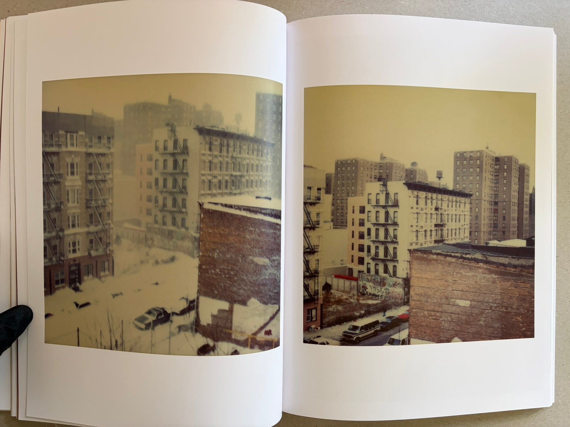 Open spread with two cityscape photographs of snowy apartment buildings.