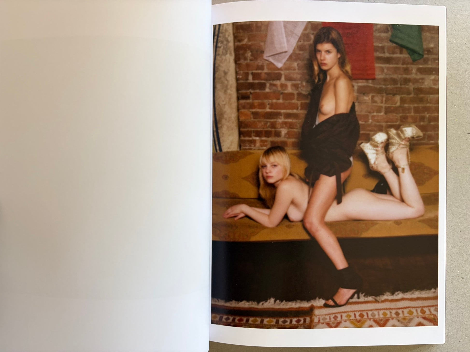 Open spread with two women posed on a sofa against a brick wall.