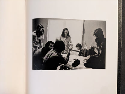 Interior spread from Return by Larry Clark showing a group gathered around a table, black-and-white photograph.