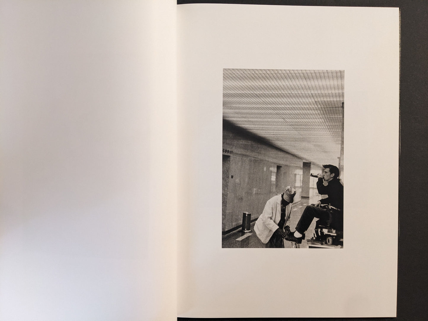 Interior spread showing a man drinking in a corridor, black-and-white photograph.