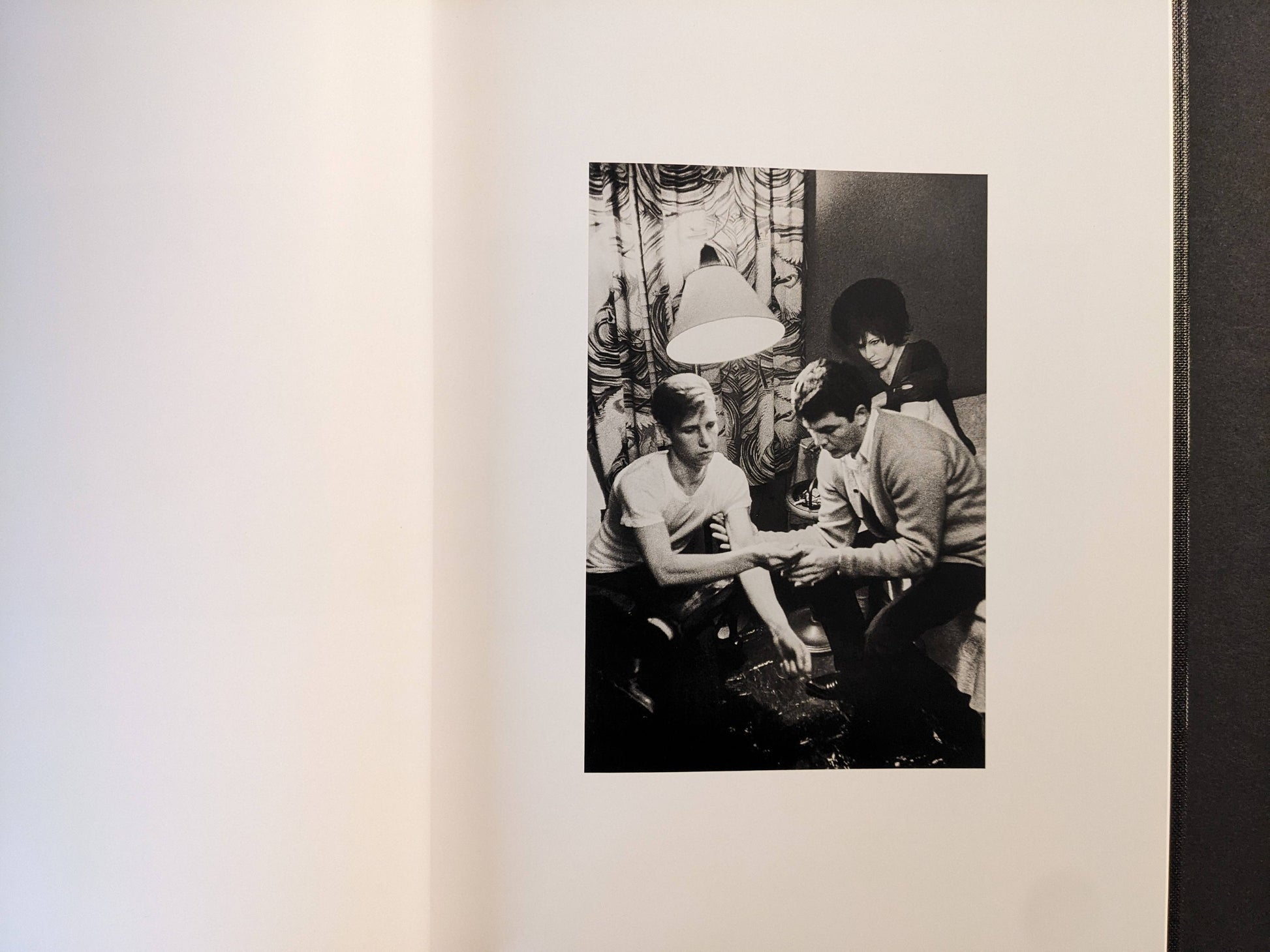 Interior spread showing an interior scene under a lamp, black-and-white photograph.