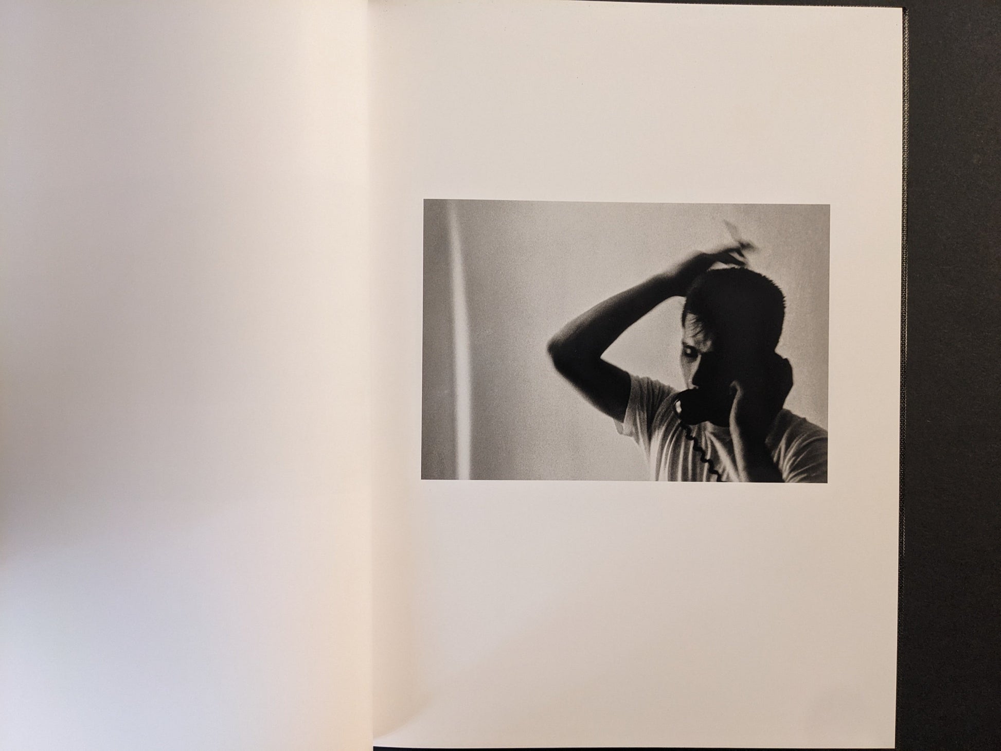 Interior spread showing a man on a telephone, black-and-white photograph.