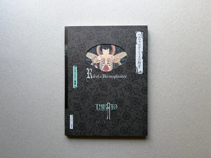 Rib of a Hermaphrodite by Takato Yamamoto, front cover of the New Black Edition with black patterned slipcase and oval cover illustration.