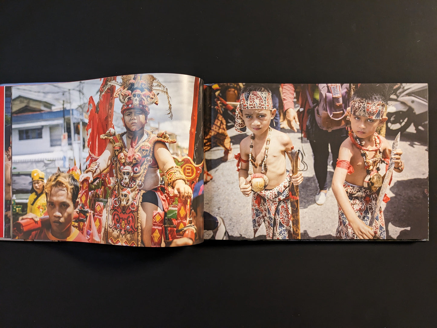 Young boys in ceremonial dress holding knives during a ritual.