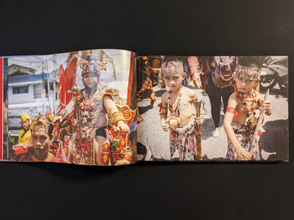 Young boys in ceremonial dress holding knives during a ritual.
