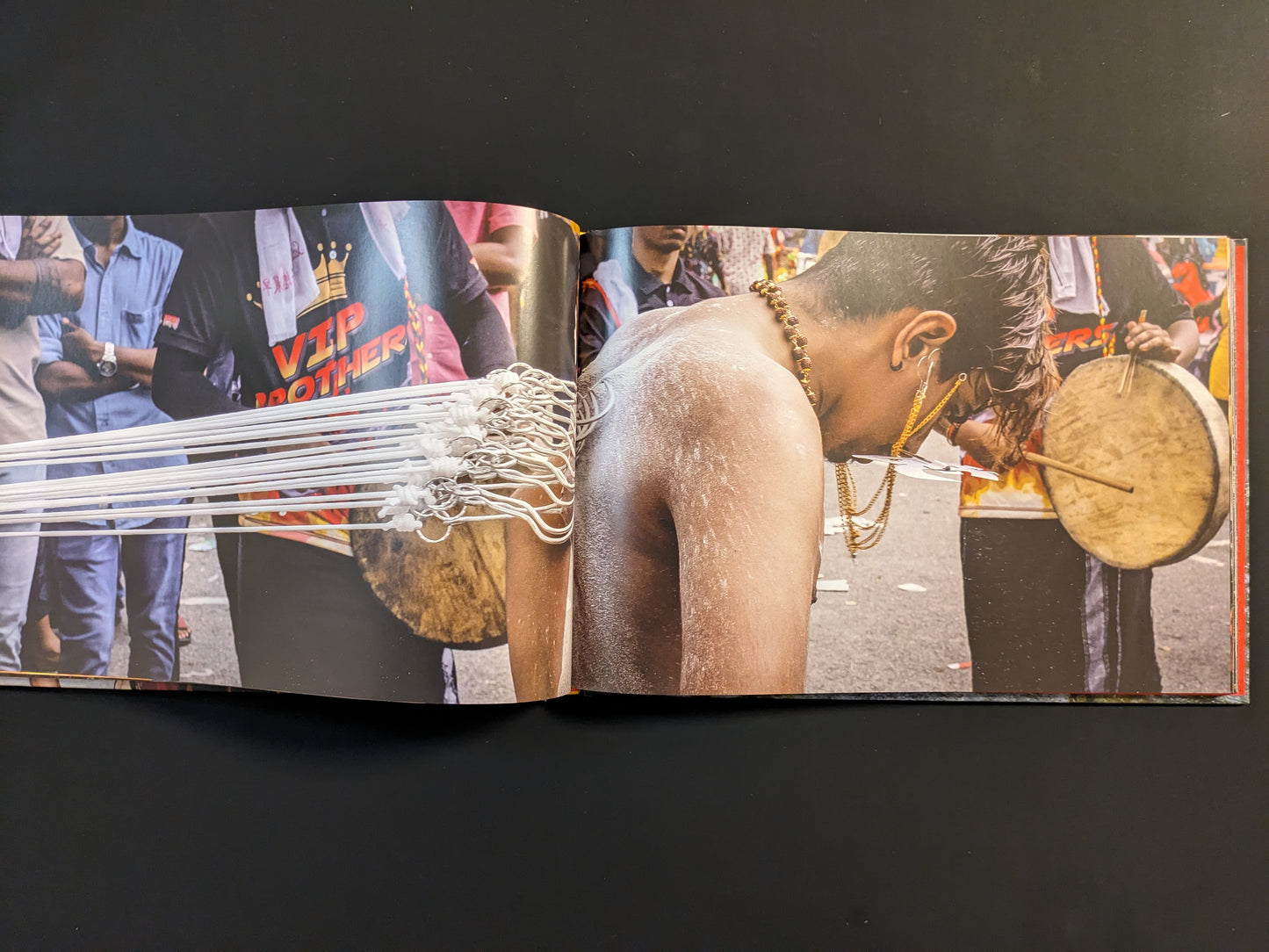 Back view of a devotee with hooks piercing his skin, connected by ropes during a Thaipusam procession.