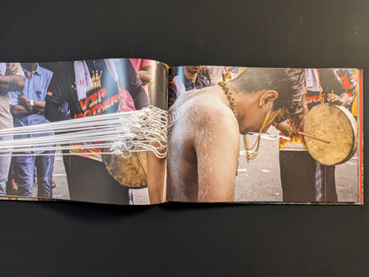 Back view of a devotee with hooks piercing his skin, connected by ropes during a Thaipusam procession.
