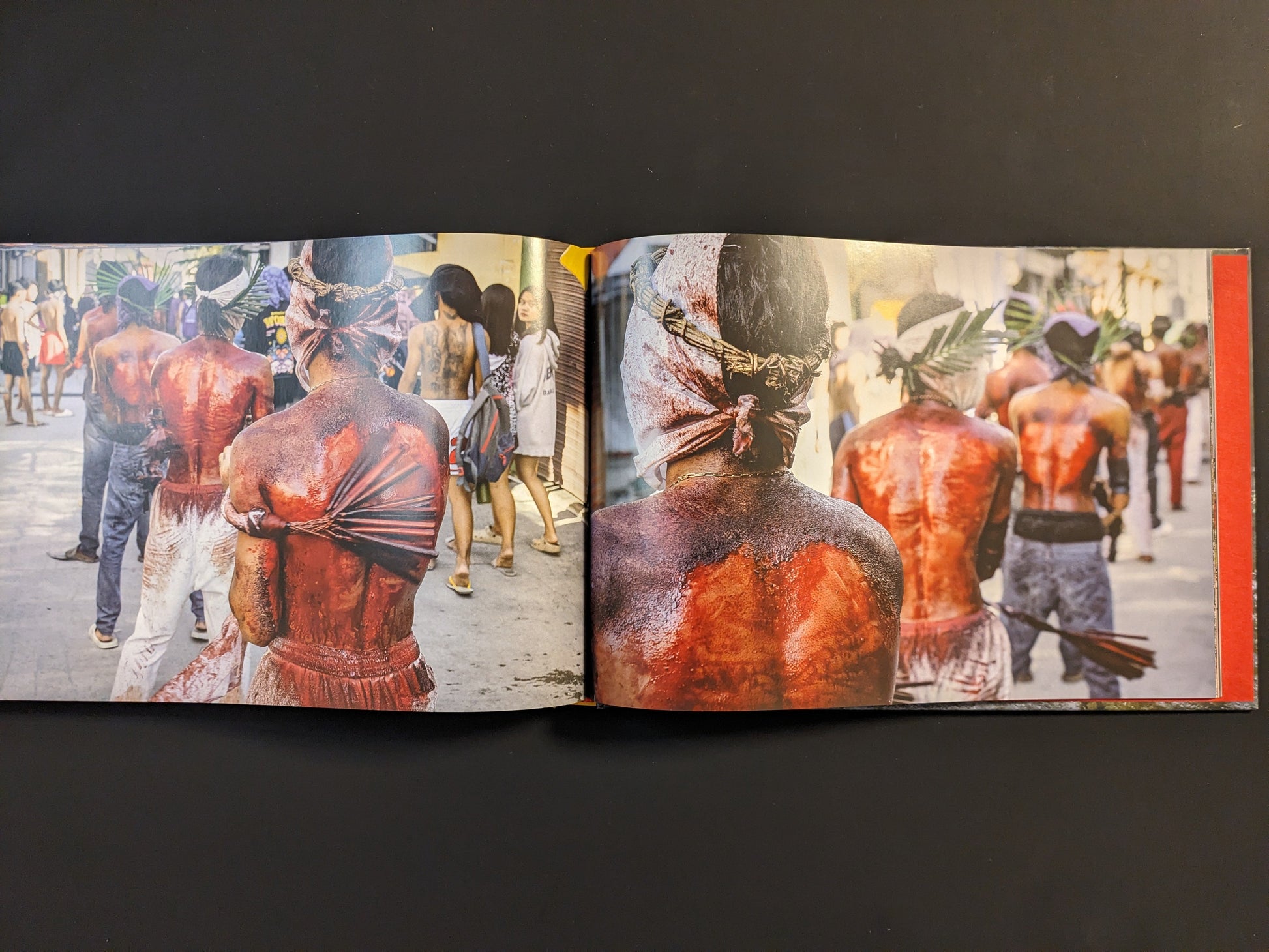 Devotees with bloodied backs perform ritual self-flagellation as part of a sacred ceremony in Southeast Asia.