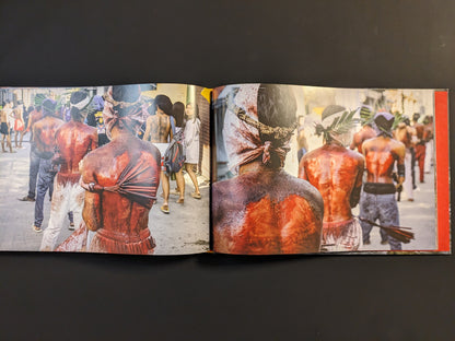 Devotees with bloodied backs perform ritual self-flagellation as part of a sacred ceremony in Southeast Asia.