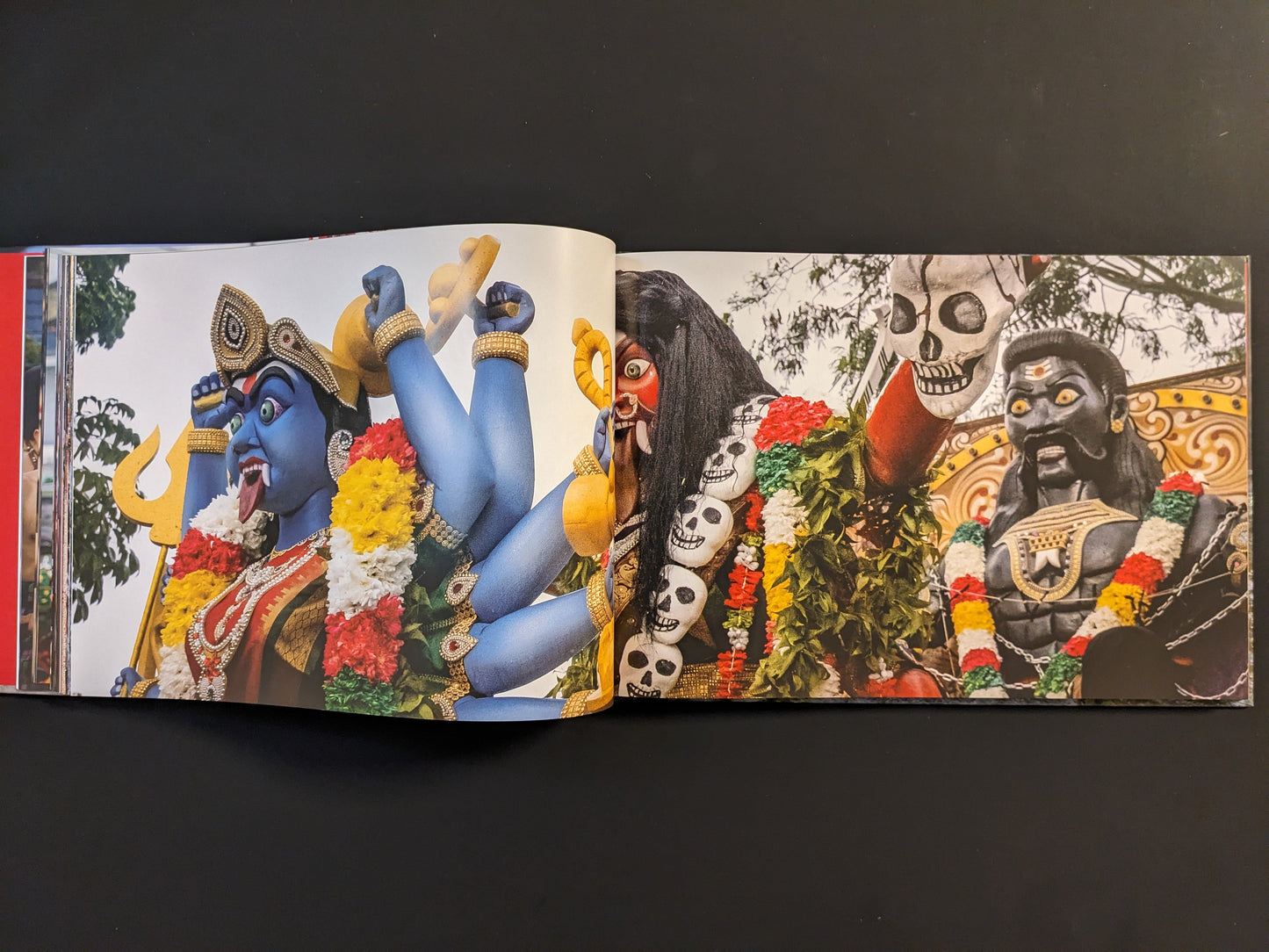 Vibrant statues of deities displayed during a Southeast Asian festival.