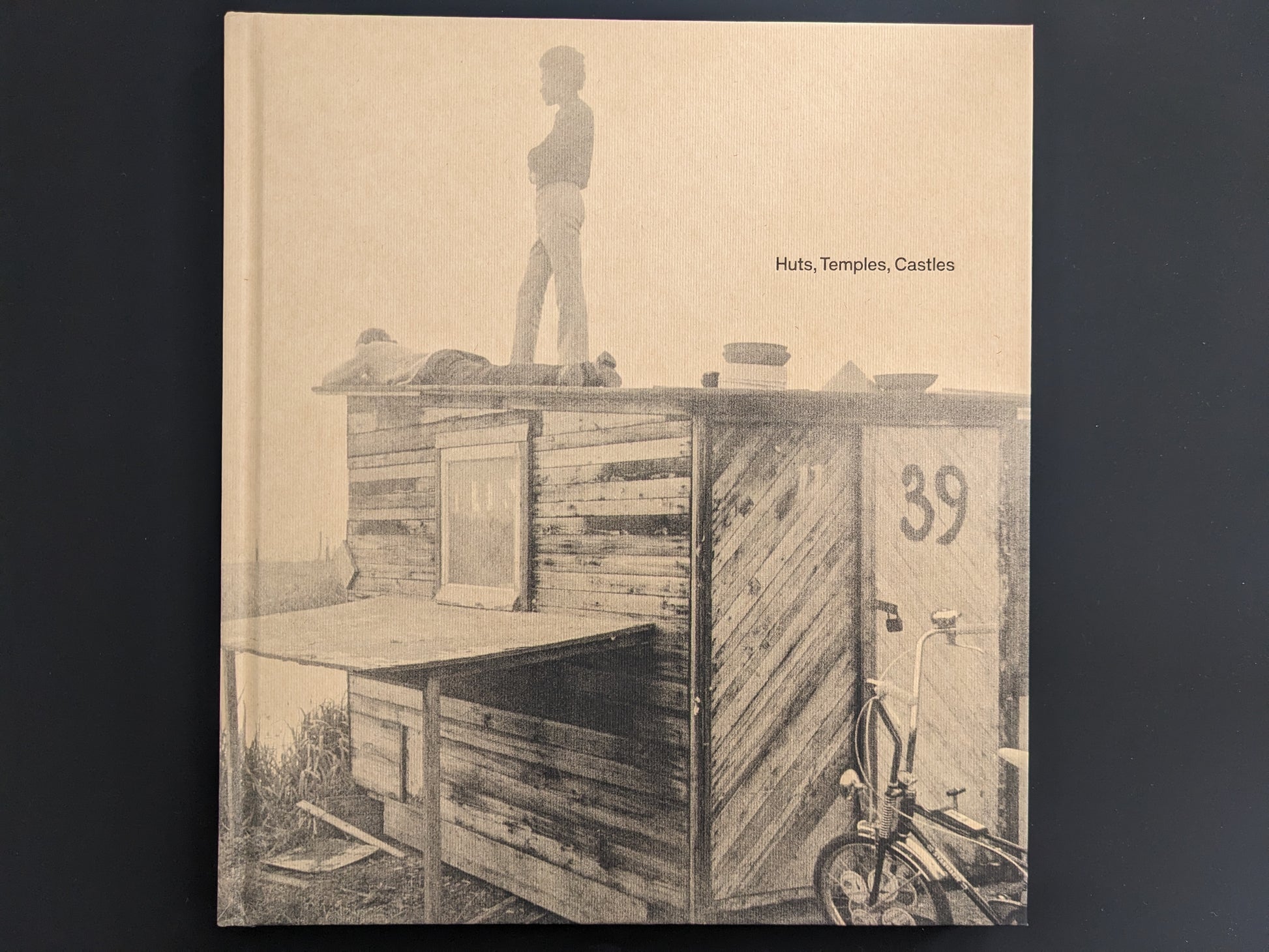 Front cover of Huts, Temples, Castles by Ursula Schulz-Dornburg – children standing on a self-built hut