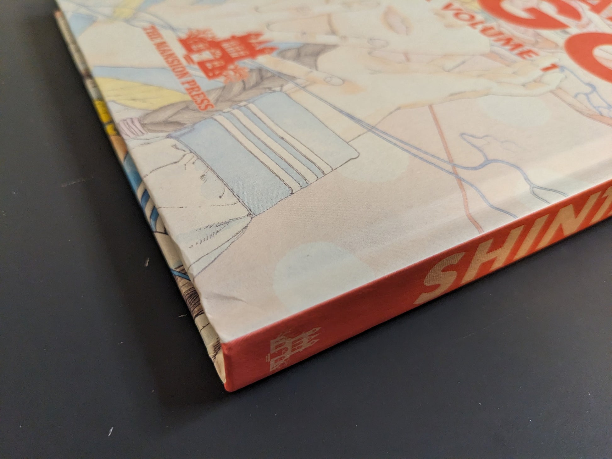 Close-up of Shintaro Kago: Artbook Vol. 1 (Third Edition) hardcover spine with soft-touch finish, spot-UV title, and The Mansion Press logo.