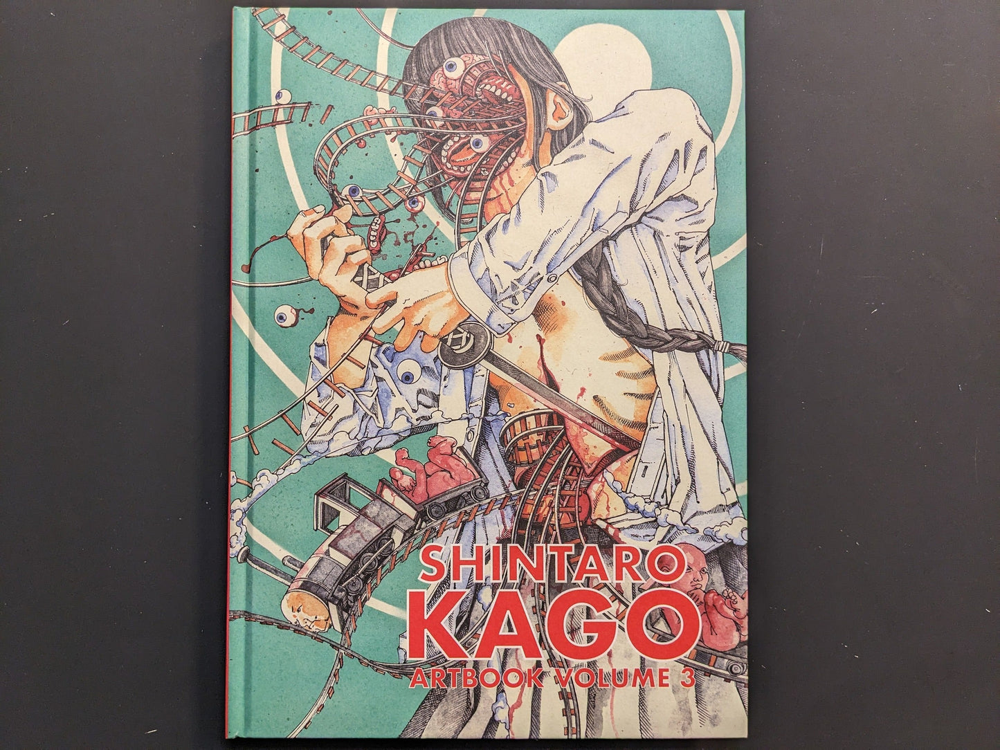 Front cover showing a surgeon figure, rollercoaster tracks and anatomical motifs from Shintaro Kago’s Artbook Vol. 3.
