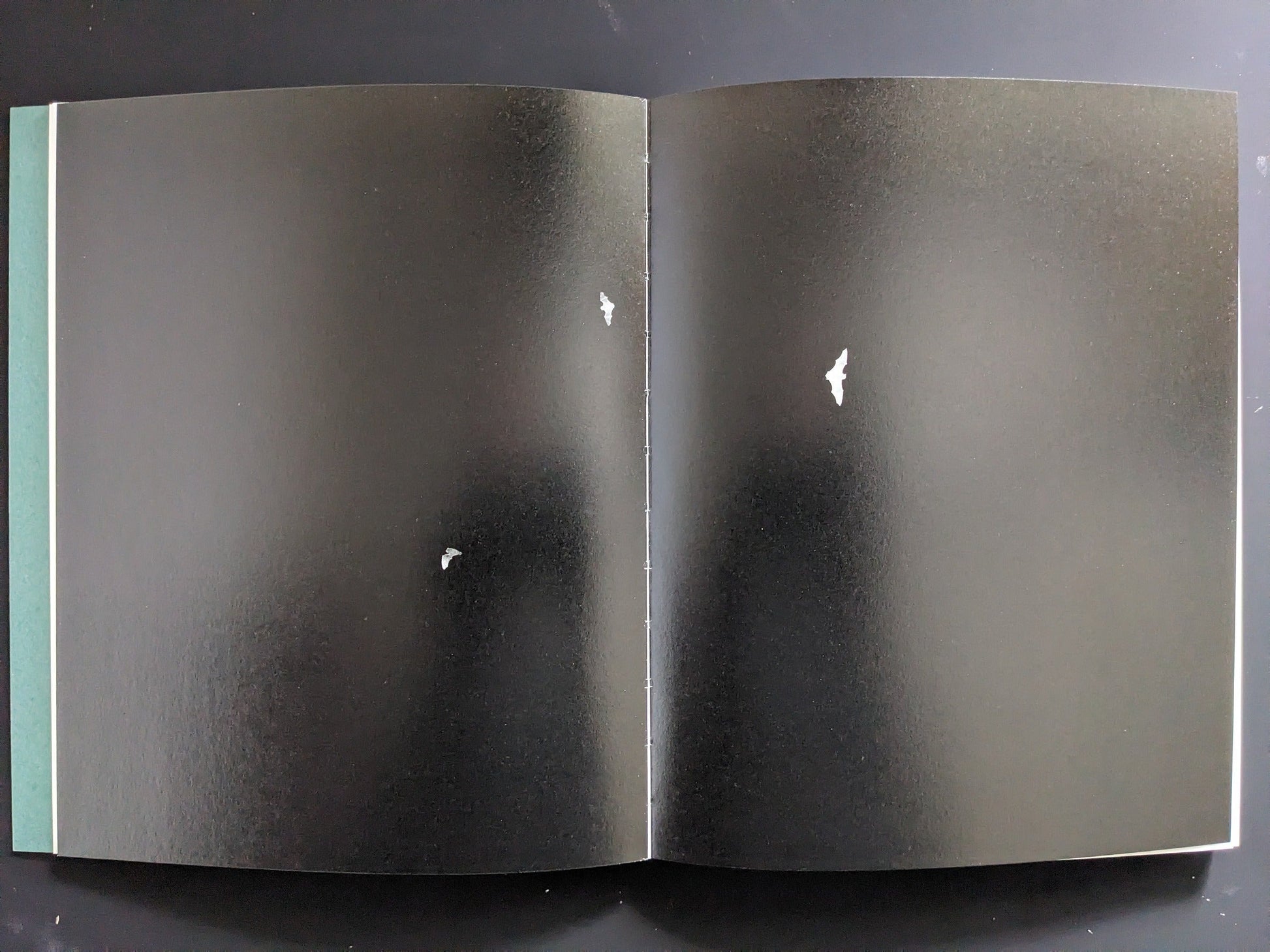 Double-page spread with three bats on black background from “Sleep Creek.”