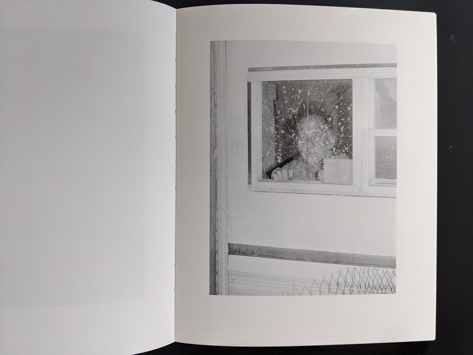 Interior spread: shattered window with impact pattern — “Sleep Creek,” New England photobook.