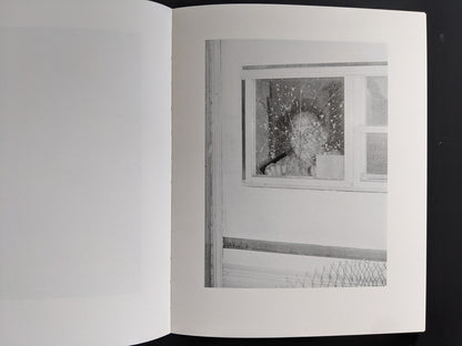Interior spread: shattered window with impact pattern — “Sleep Creek,” New England photobook.