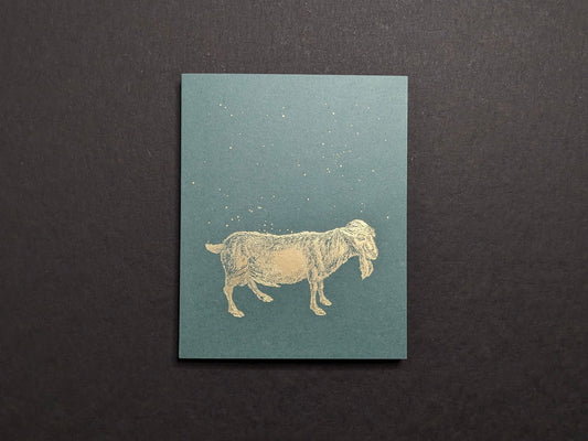 Front cover: teal board with a gold-foil goat and scattered dots.