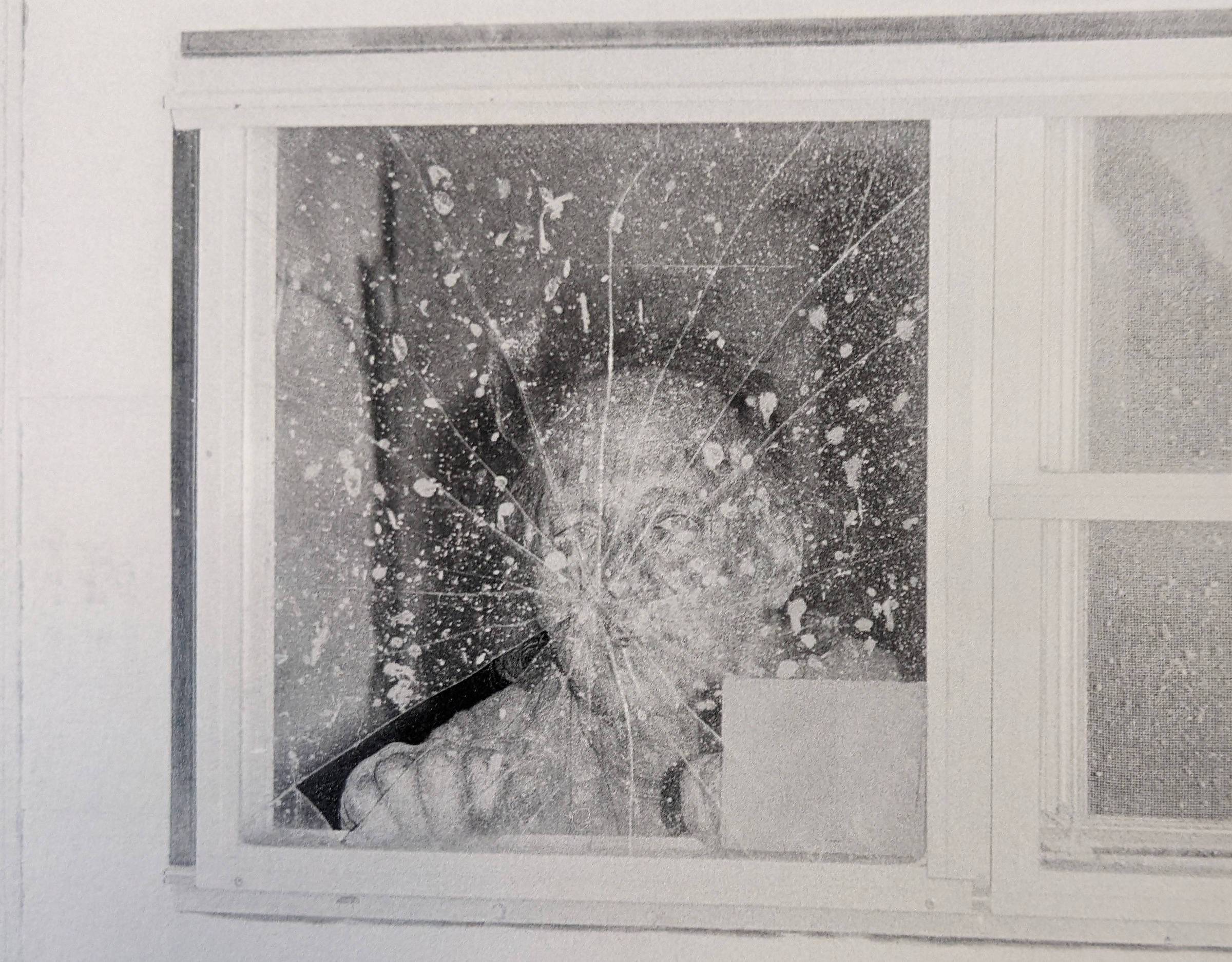 Black-and-white photograph from the photobook "Sleep Creek" showing a face behind a cracked, splattered window.