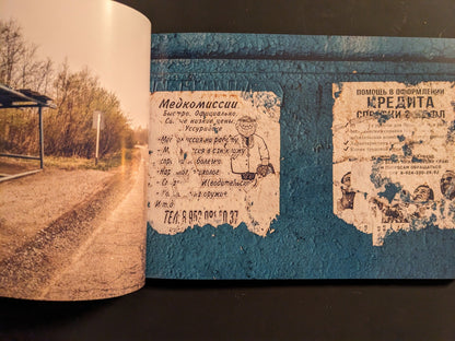 Interior spread: torn Russian posters on a blue wall beside the concrete underside of a Soviet-era bus shelter.