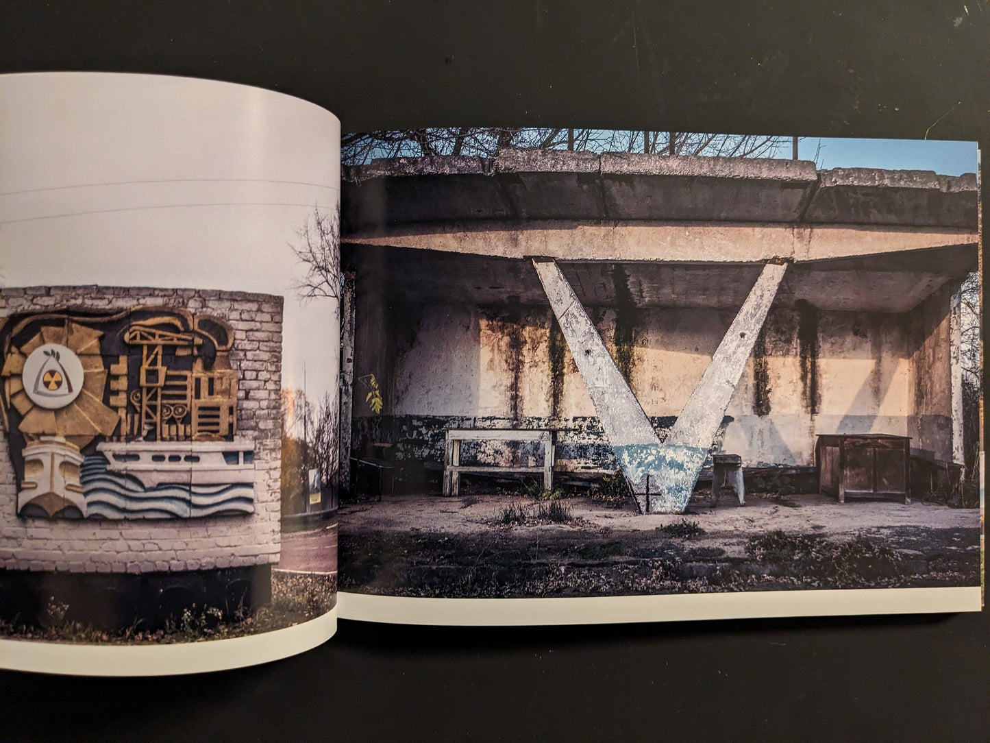 Interior spread: A-frame concrete bus shelter on left; emblematic wall mosaic with industrial and atomic motifs on right.