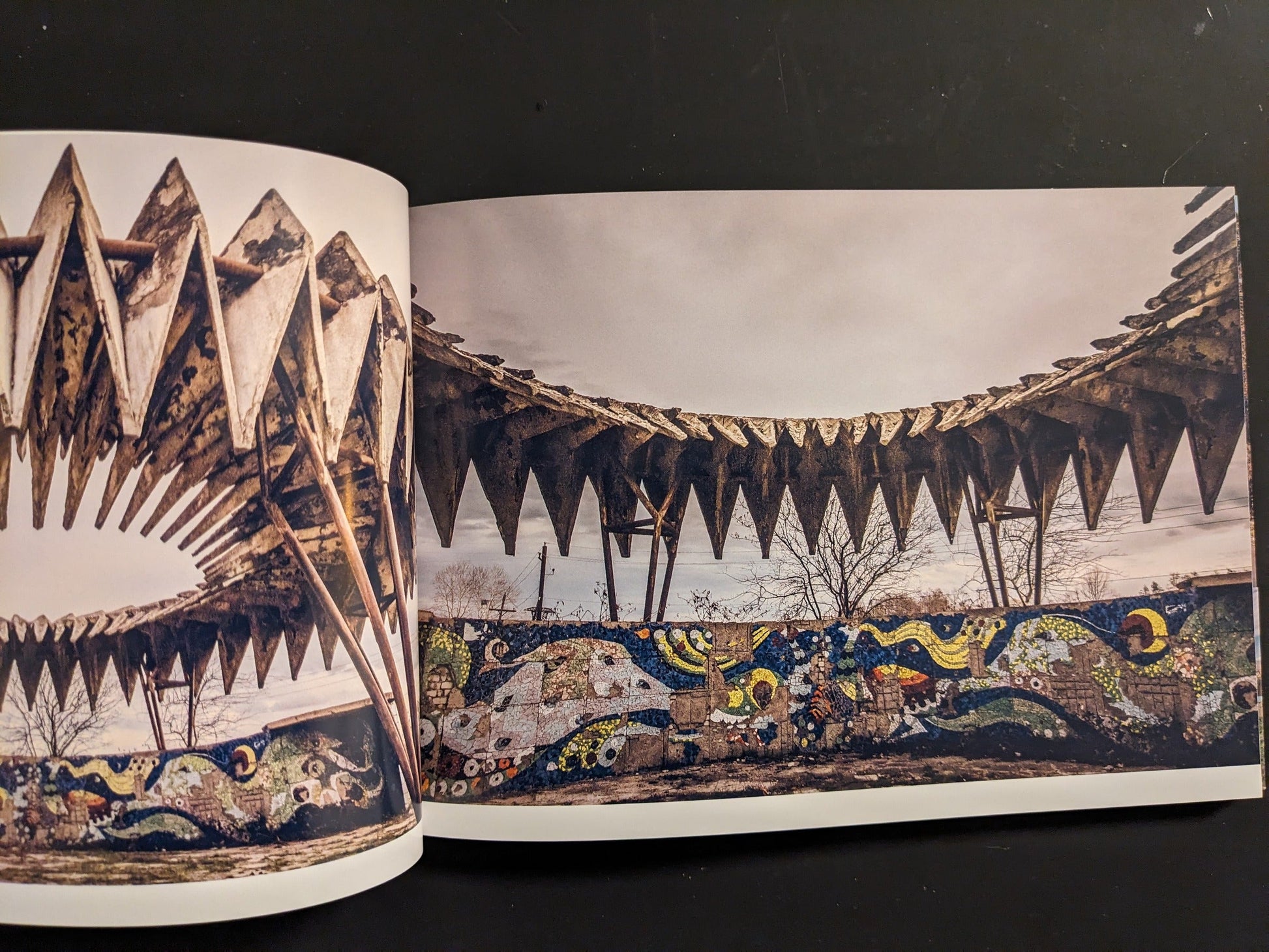 Interior spread: dramatic sawtooth concrete canopy with colorful mosaic frieze of waves and stars.