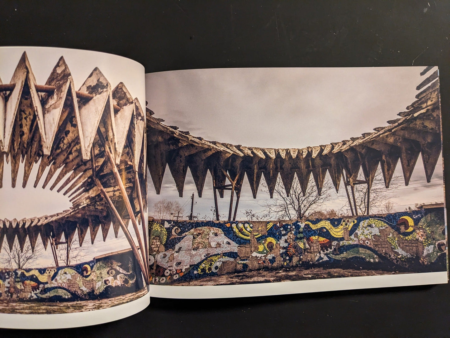 Interior spread showing a sawtooth concrete canopy and a colorful mosaic frieze of waves and stars.