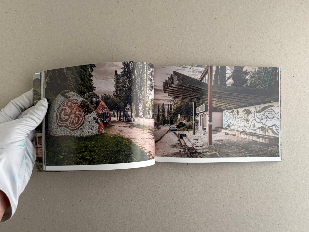 Open spread from Soviet Architectural Design by Hoshino Ai, showing a low bus stop with painted figures on the left and a brick wall mural on the right.