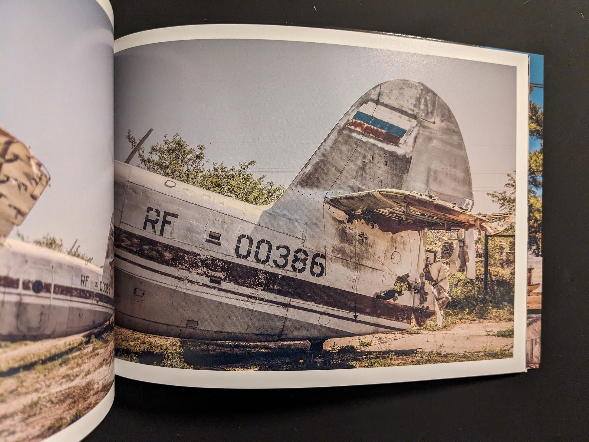 Damaged Soviet military aircraft with torn control surfaces and faded RF markings, photographed in situ.