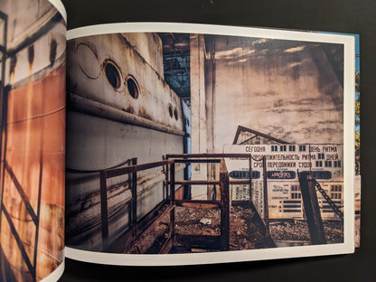Interior spread: industrial scene with Cyrillic warning signs beside a rusted ship hull and metal structure.