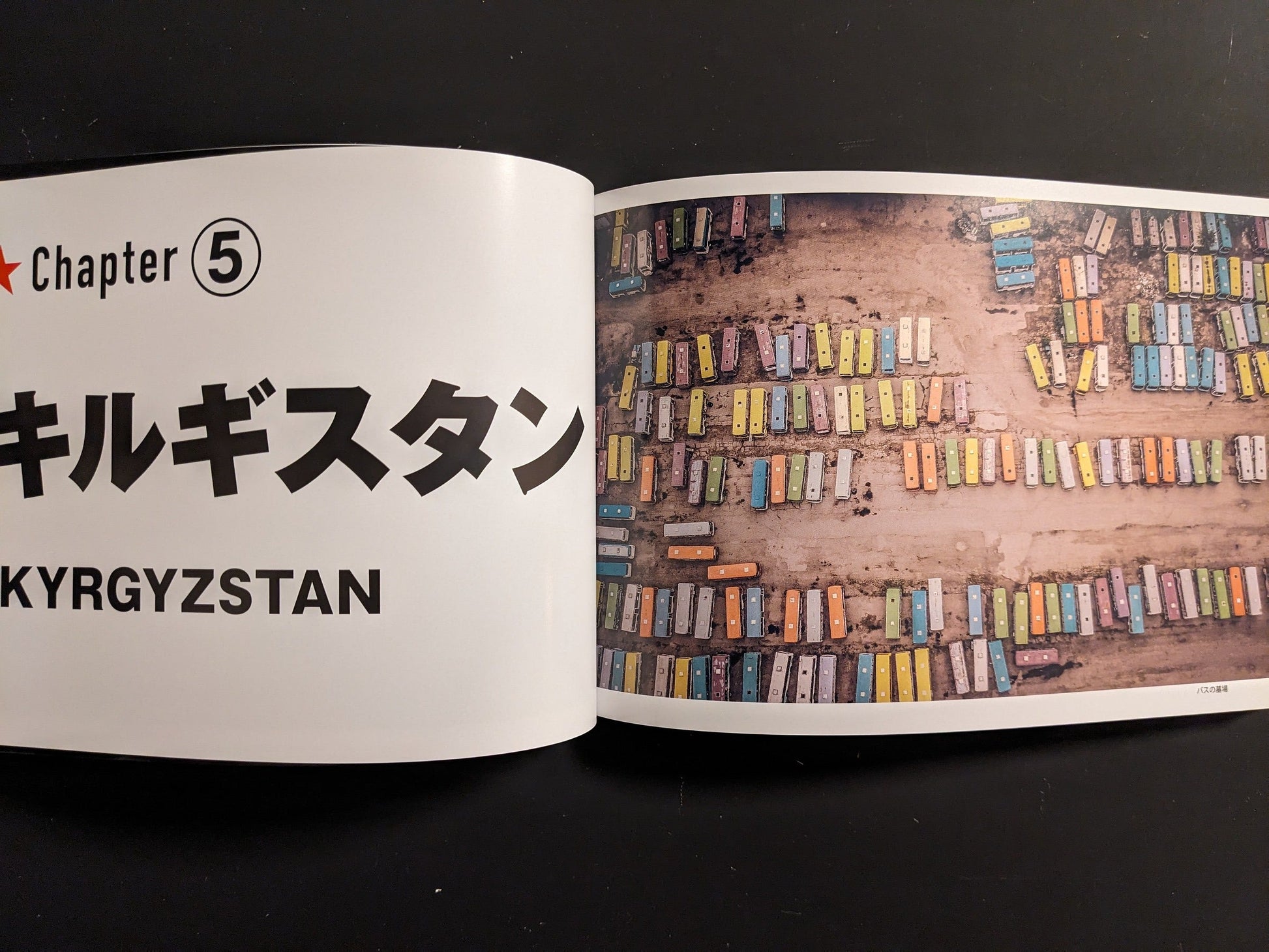 Spread opening “Kyrgyzstan” chapter with aerial rows of colorful buses at a depot.
