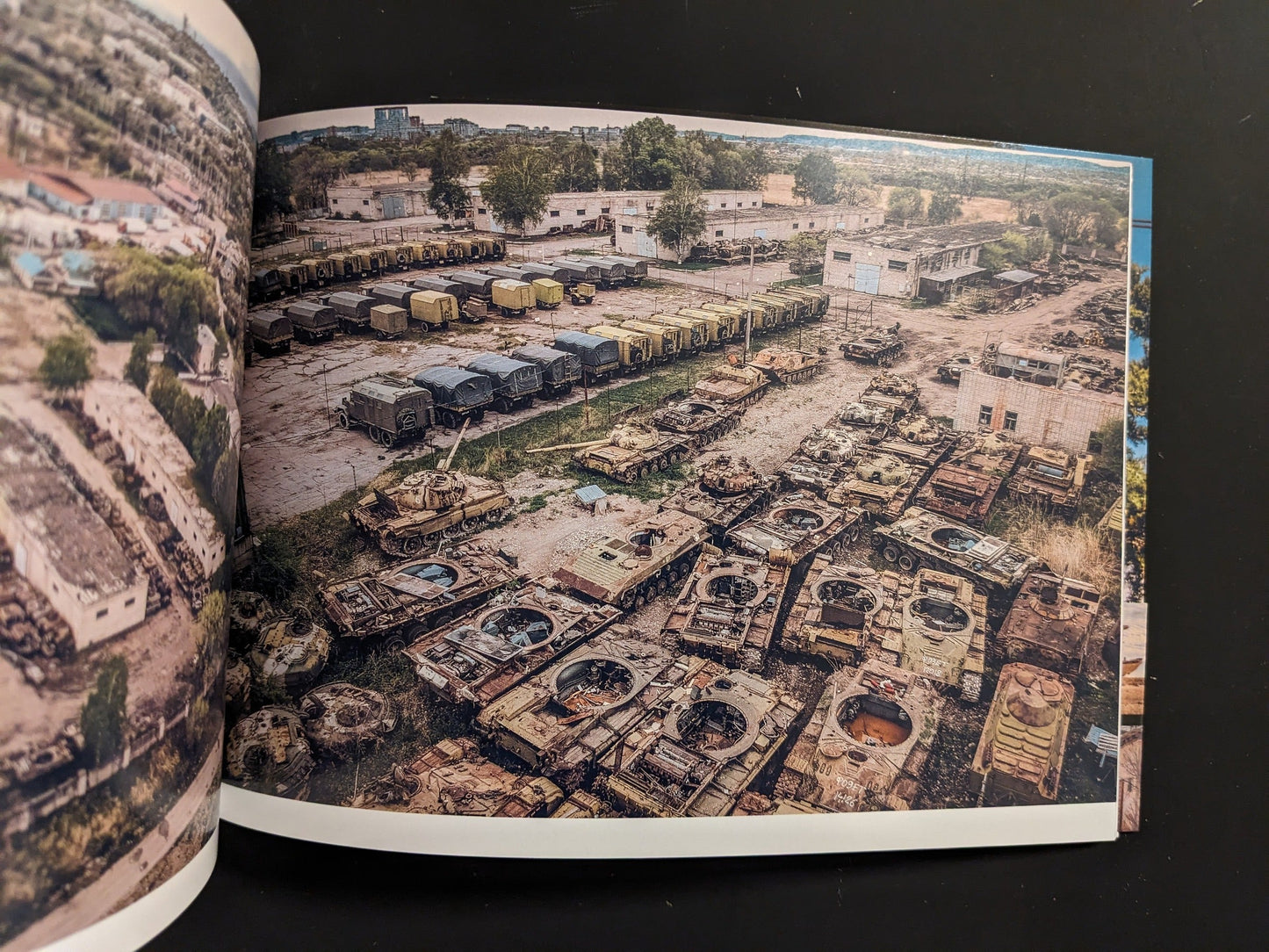 Aerial view of derelict Soviet tanks and armored vehicles arranged in rows at a scrapyard.
