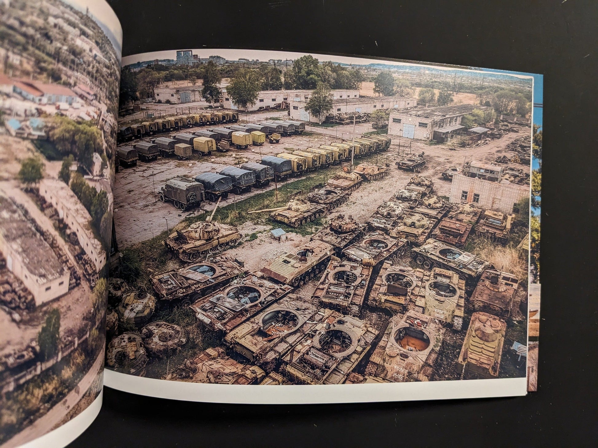 Aerial view of derelict Soviet tanks and armored vehicles arranged in rows at a scrapyard.
