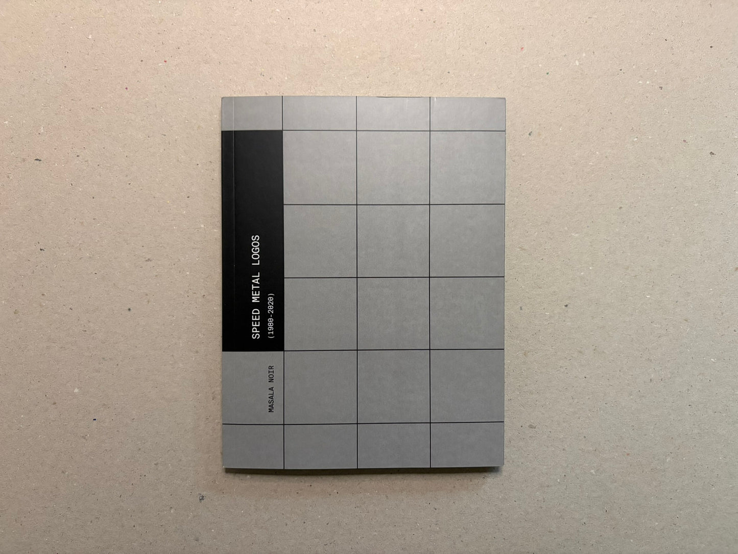 Speed Metal Logos (1990–2020) cover on a beige surface, grey grid design with a black vertical band