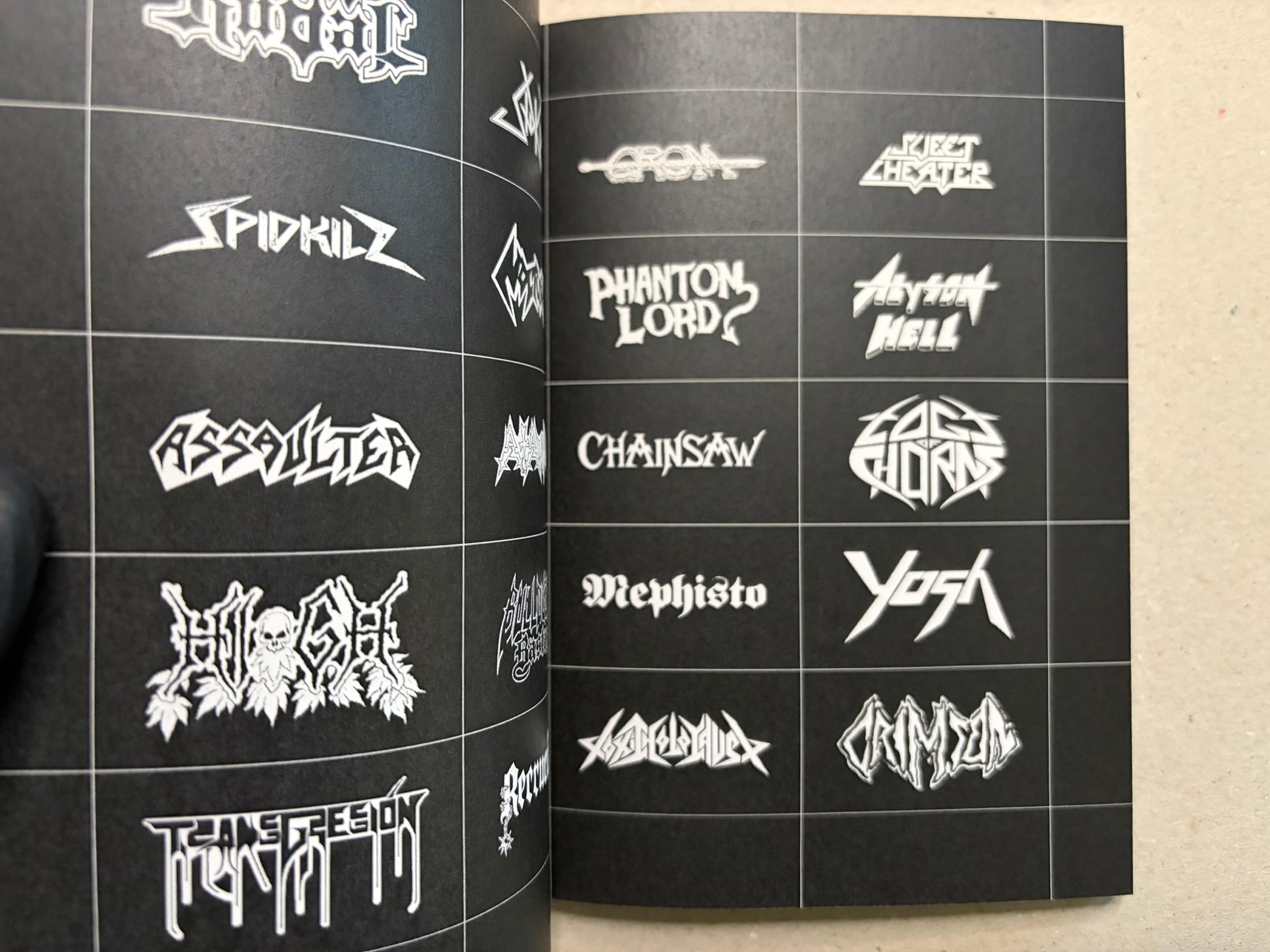 Open spread of speed metal logos, including sharp white band marks on black pages