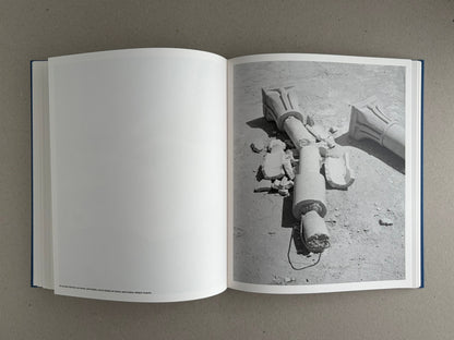 Open spread of Sub Sole by Massao Mascaro, with a black-and-white photograph of broken classical column fragments on the right page and a blank left page.