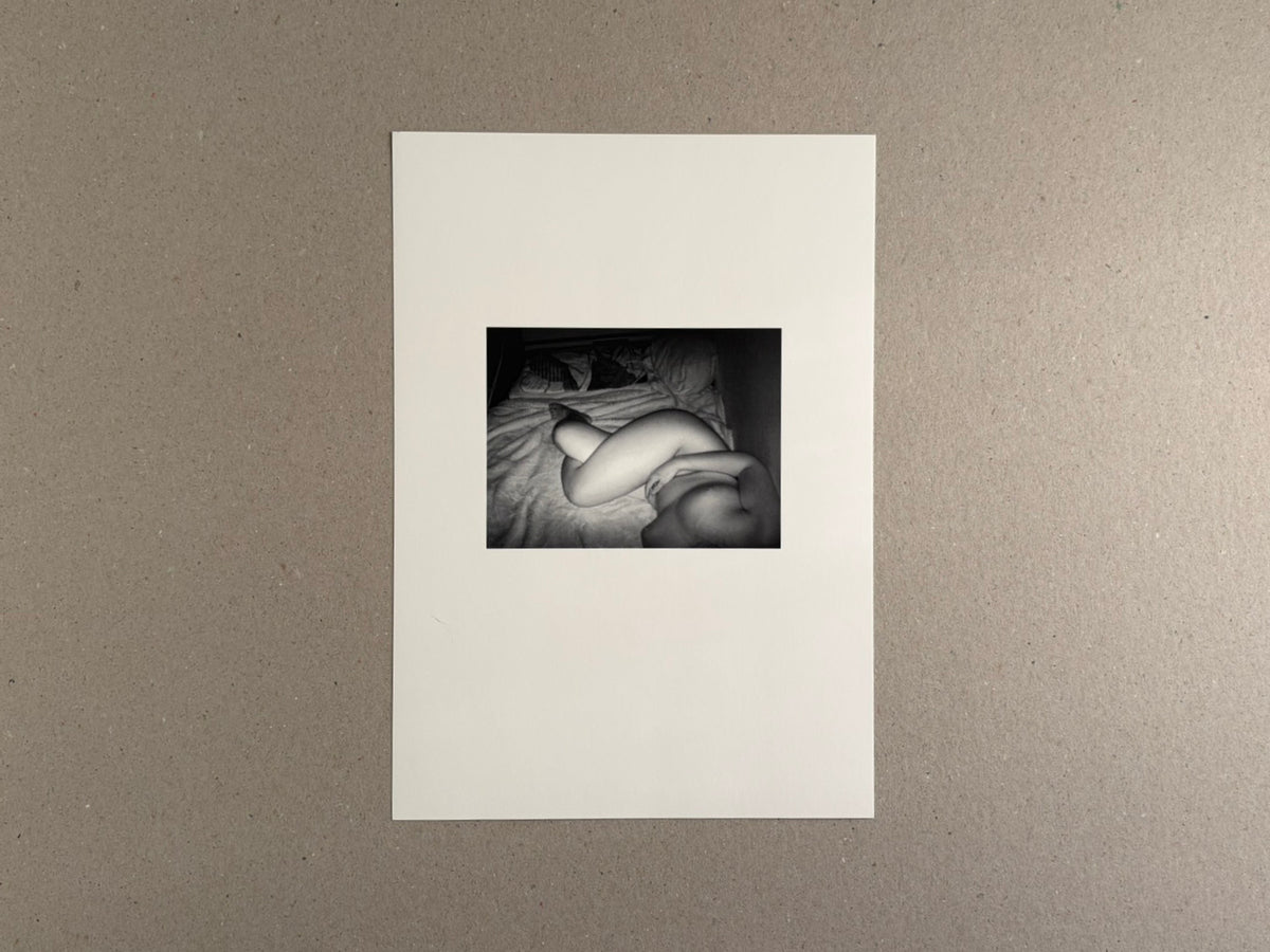 Surveillance – Tsutomu Yamagata, printed page with a small black-and-white photograph of a reclining nude figure on a bed.