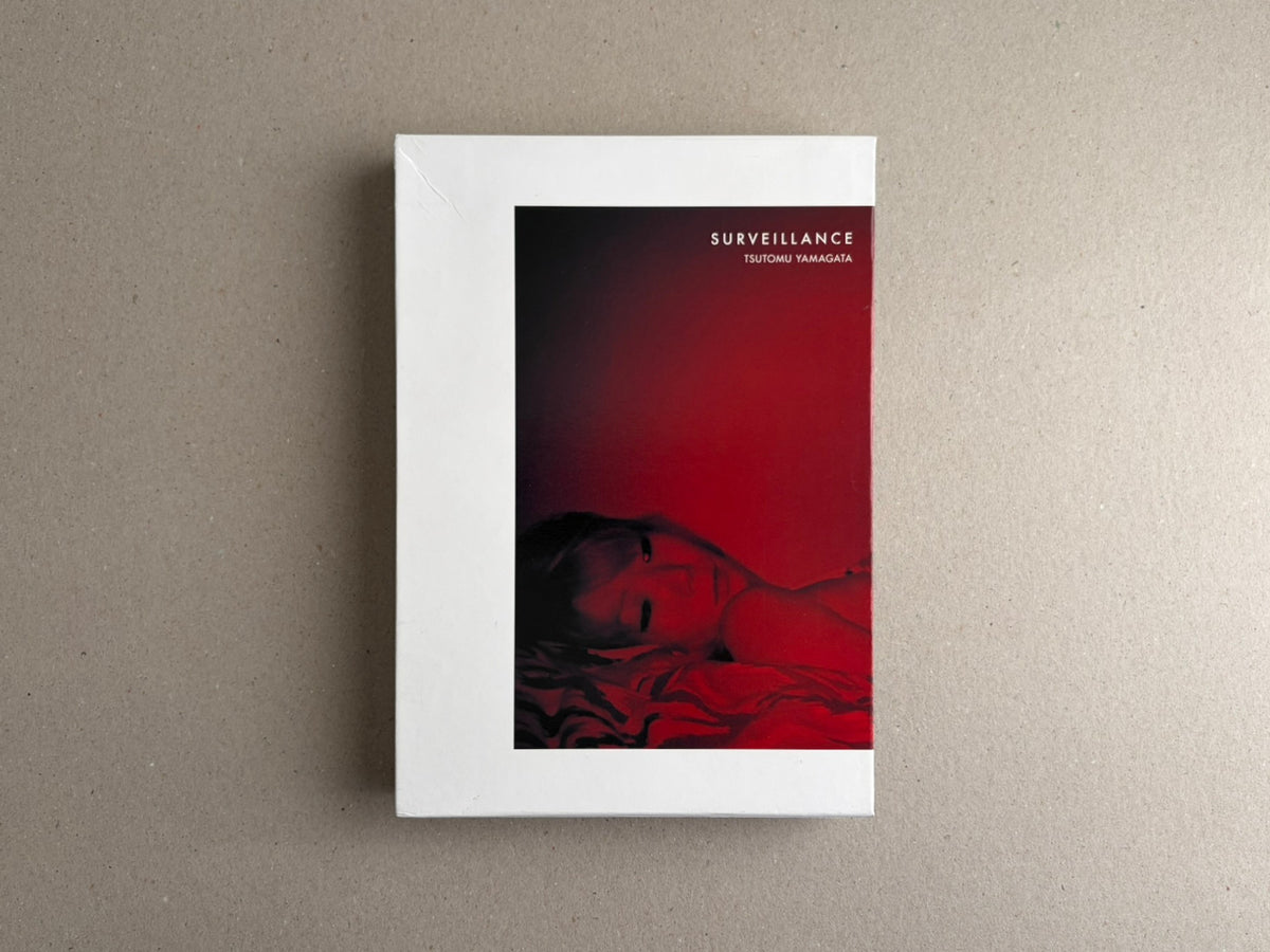 Surveillance – Tsutomu Yamagata, front cover shown on a white slipcase with a red-and-black cover image.